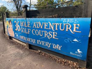 Outdoor blue sign of the Adventure 36 hole golf course at Bluewater shopping centre